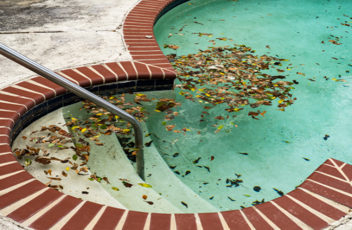 Pool winterization - pool with fallen leaves collected inside of it