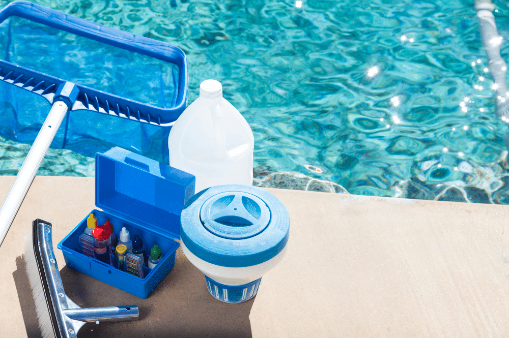 Equipment for a pool cleaning service sitting next to a swimming pool